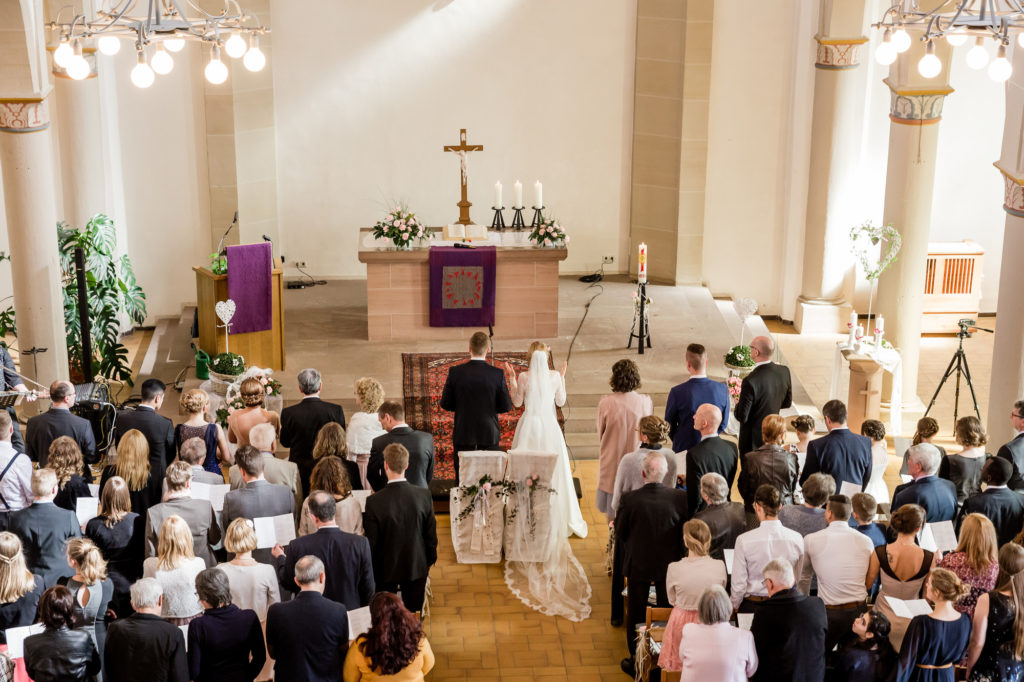 Hochzeitzeremonie in der Kirche: Das Brautpaar steh vor dem Altar.